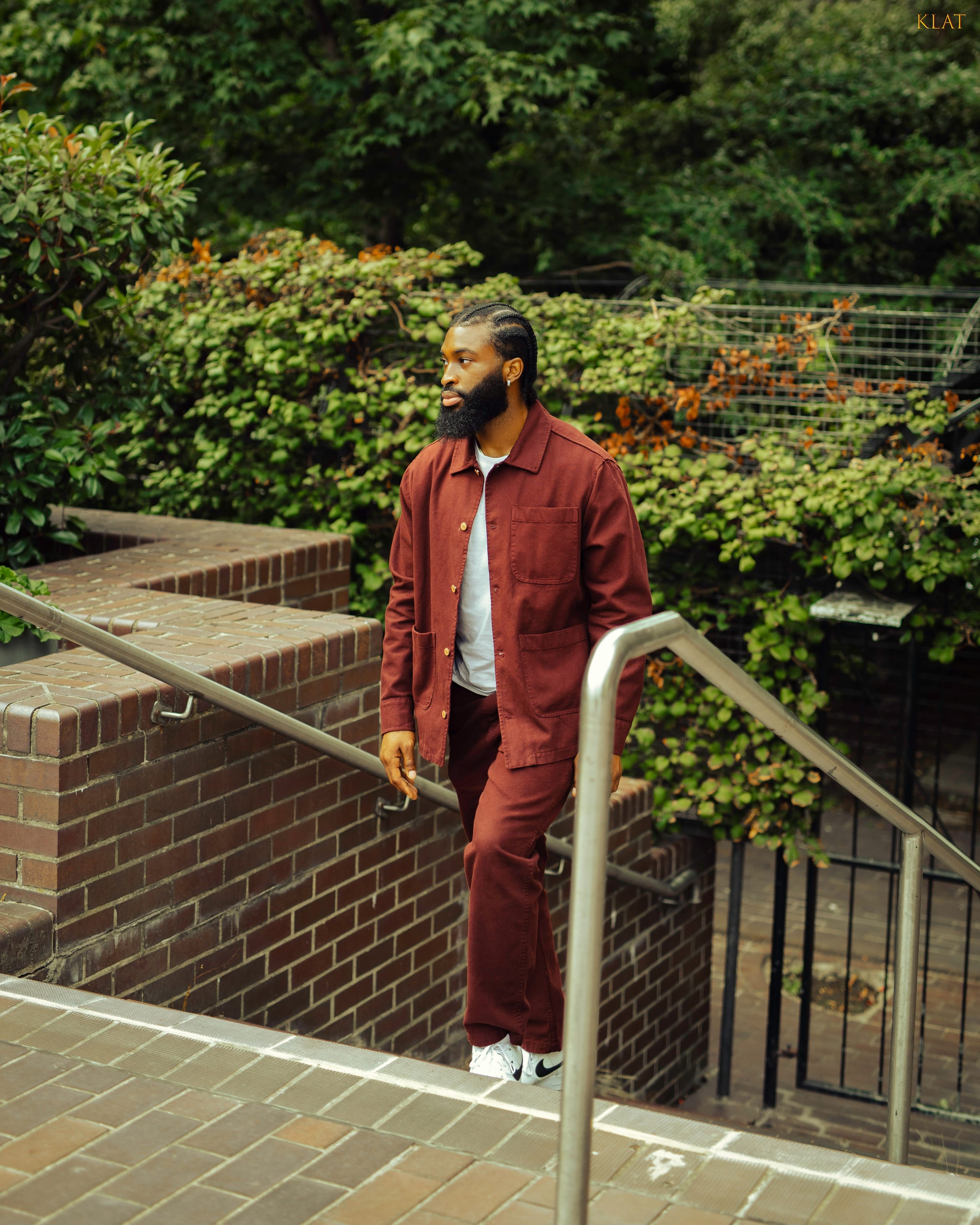 Full-body portrait in a rust outfit on urban brick stairs